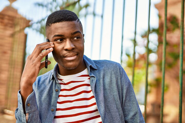 Young african american man smiling happy talking on the smartphone at the city.