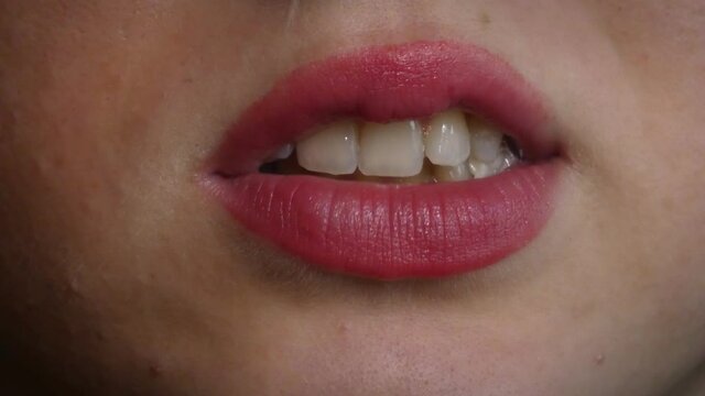 Beautiful young woman chewing a gum, 4K mouth detail, wearing lipstick
