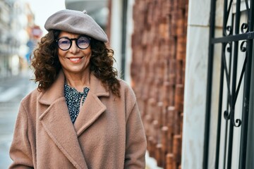 Obraz premium Middle age hispanic woman smiling happy standing at the city.