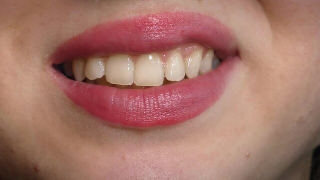 Beautiful young woman chewing gum, 4K mouth detail, wearing lipstick
