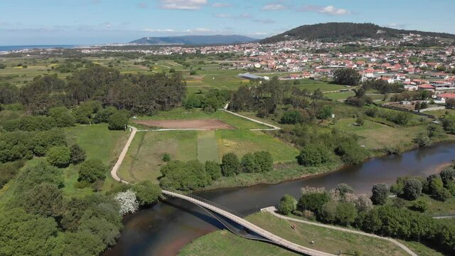 DRONE AERIAL FOOTAGE: Rio Neiva Bridge - Ecovia Litoral Norte (North Coast Ecoway). Pedestrian, cycle bridge over the Neiva river in Antas, Esposende, Portugal.
