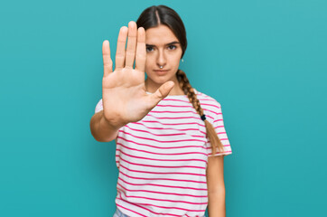 Young hispanic woman wearing casual clothes doing stop sing with palm of the hand. warning...