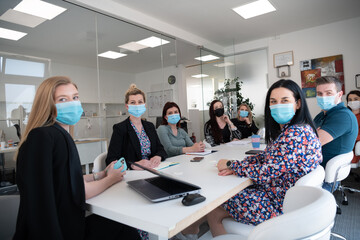 Naklejka premium real business people on meeting wearing protective mask
