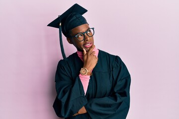 Young african american girl wearing graduation cap and ceremony robe thinking worried about a question, concerned and nervous with hand on chin