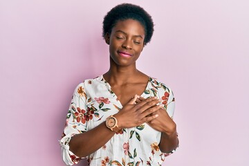 Young african american girl wearing casual clothes smiling with hands on chest with closed eyes and grateful gesture on face. health concept.