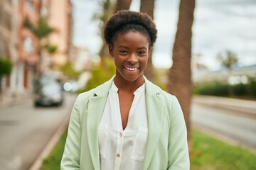 Obraz premium Young african american businesswoman smiling happy standing at the city