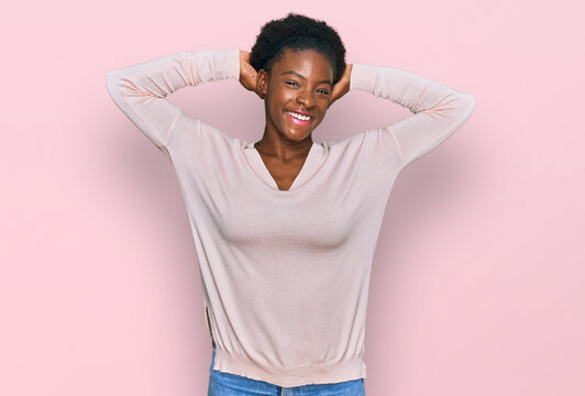 Young african american girl wearing casual clothes relaxing and stretching, arms and hands behind head and neck smiling happy
