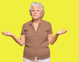 Senior grey-haired woman wearing casual clothes clueless and confused expression with arms and...