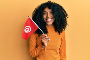 African american woman with afro hair holding turkey flag looking positive and happy standing and smiling with a confident smile showing teeth