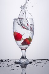 Strawberries dropped in water glass.