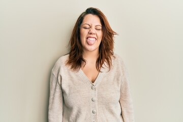 Obraz premium Young caucasian woman wearing casual clothes sticking tongue out happy with funny expression. emotion concept.