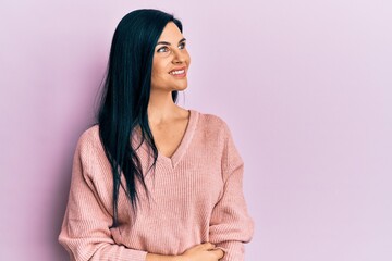 Young caucasian woman wearing casual clothes looking away to side with smile on face, natural expression. laughing confident.