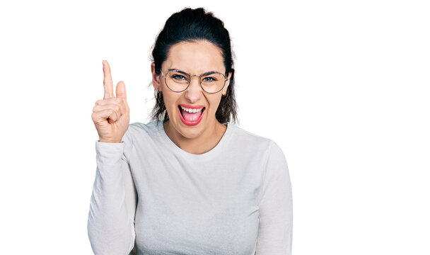 Young hispanic woman wearing casual clothes pointing finger up with successful idea. exited and happy. number one.