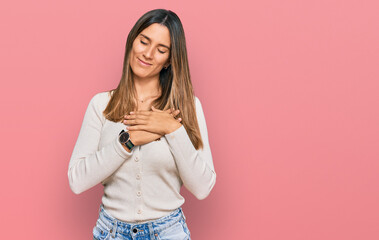 Young woman wearing casual clothes smiling with hands on chest with closed eyes and grateful gesture on face. health concept.
