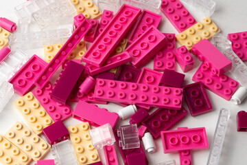Construction brick game, pink white and glass coloured plastic bricks. 