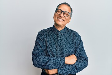 Middle age indian man wearing casual clothes and glasses happy face smiling with crossed arms...