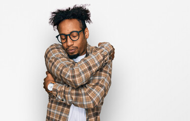 Young african american man with beard wearing casual clothes and glasses hugging oneself happy and positive, smiling confident. self love and self care