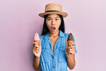 Young chinese woman wearing summer style holding ice cream in shock face, looking skeptical and sarcastic, surprised with open mouth