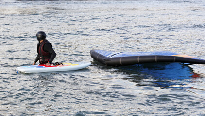 Naklejka premium waterman with complete equipment, paddleboard and hydrofoil in the water