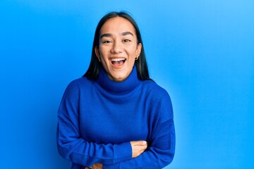 Young asian woman wearing casual winter sweater smiling and laughing hard out loud because funny...