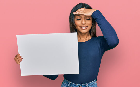 Young latin transsexual transgender woman holding blank empty banner stressed and frustrated with hand on head, surprised and angry face