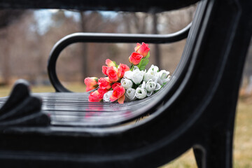 Bouquet of flowers left on park bench as a memorial. 