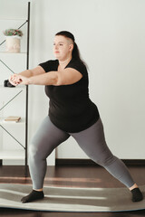 Overweight woman doing physical exercises at home