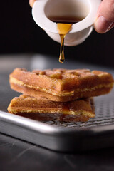 waffle freshly made and dipped with maple honey

