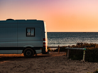 Camper car on beach at sunrise