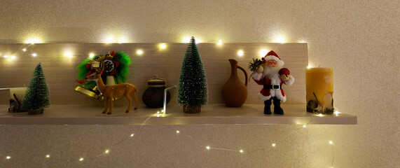 Santa Claus, deer, Christmas trees stand on the shelf