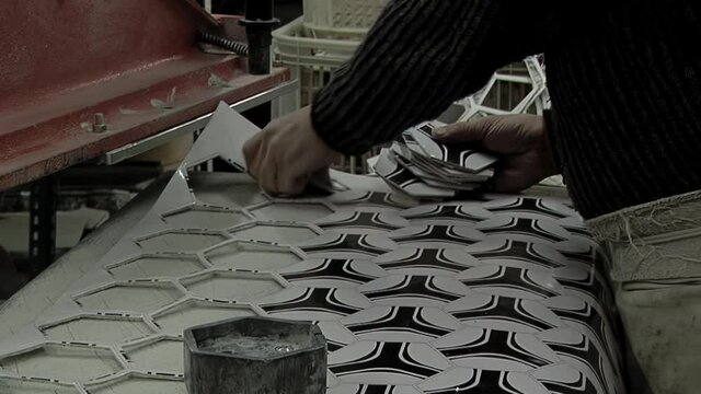 Worker Hand cutting Pieces of Synthetic Hexagons and Pentagons at a Football Ball Factory. Close Up.