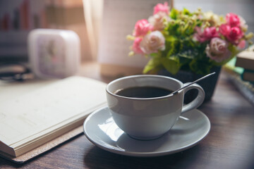 Coffee Break Time. A cup of coffee, diary, clock, calendar, and Rose Flower vase place on home office.