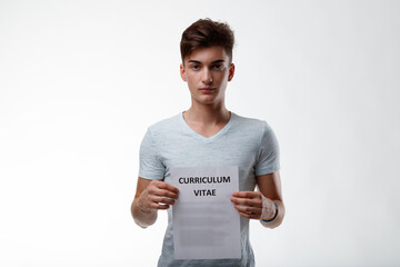 Serious young job seeker holding up his Curriculum Vitae to his