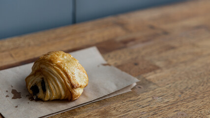 Croissants, sweets, snacks placed on paper and wooden floor.