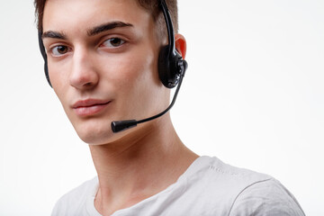 Cropped portrait of a young man wearing a headset looking at cam