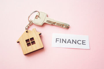 Wooden house toy and silver key on bright pink