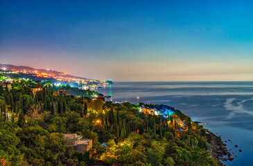 Green sea shore with residential buildings in the night