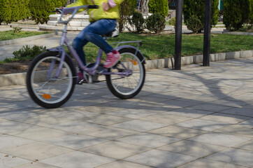 Blurred motion of a child riding a bicycle.
