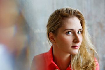 Close-up portrait of a blonde girl with highlights and reflection in the foreground.