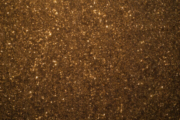 Shiny brown abstract background. Bright glowing sparks on a brown texture.