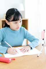 スマートフォンを見ながら勉強する女の子