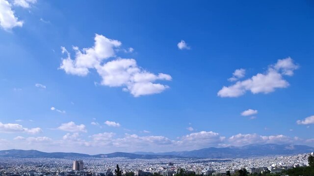 Wide panorama of city, time-lapse, white clouds floating in blue sky, Athens in Greece