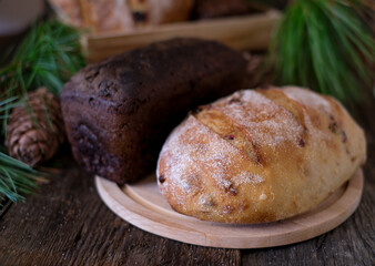 Obraz na płótnie Canvas Assorti of brown and white homemade fermented bread with cedar nuts at dark wooden background