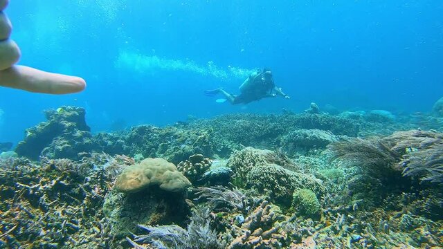 Scuba diver hooked onto rock with a reef hook in very strong ocean current