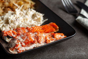 A serving of oven cooked marinated salmon fillets with cabbage and celery salads to increase fiber and vitamin content. A healthy balanced diet concept