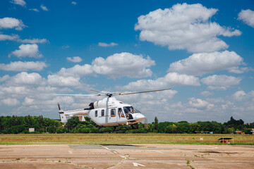 A white helicopter takes off from the runway