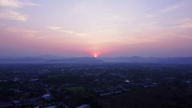 Establishing Aerial View Shot of sunrise with fog above asia village, Golden hour.