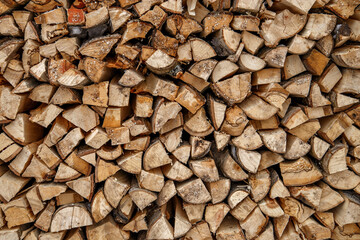 Split logs are stacked in smooth pile of firewood