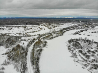 Aerial view of a moving small train that travels on a narrow gauge railway in winter (Kirovo-Chepetsk, Kirov region, Russia)