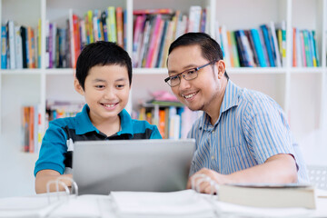 Preteen student with his teacher and laptop